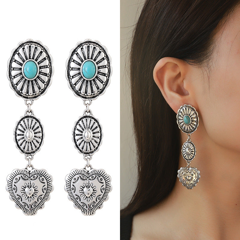 Silver earrings with turquoise stones worn by a person