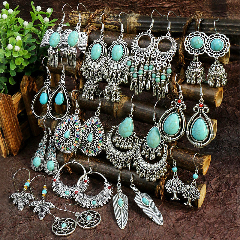 Collection of dangly silver earrings with turquoise accents. 