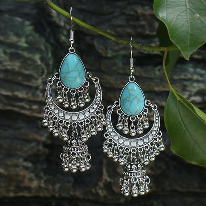 Pair of silver earrings with turquoise stones on a natural background