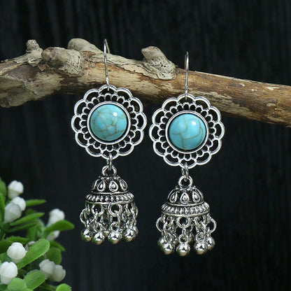 Silver earrings with turquoise stones on a dark background
